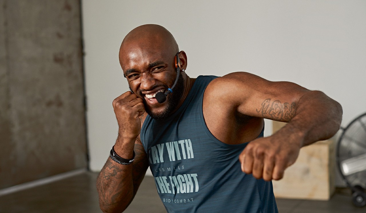 Man in red shirt doing high knees on turf