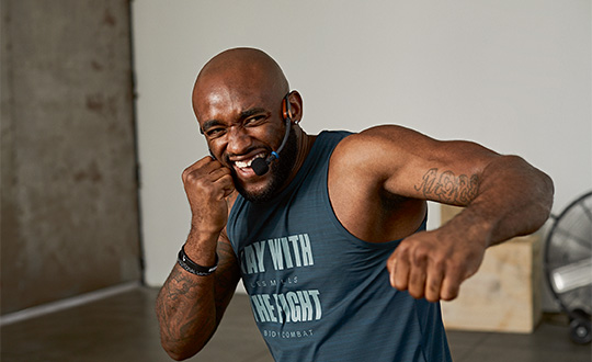 Man in red shirt doing high knees on turf