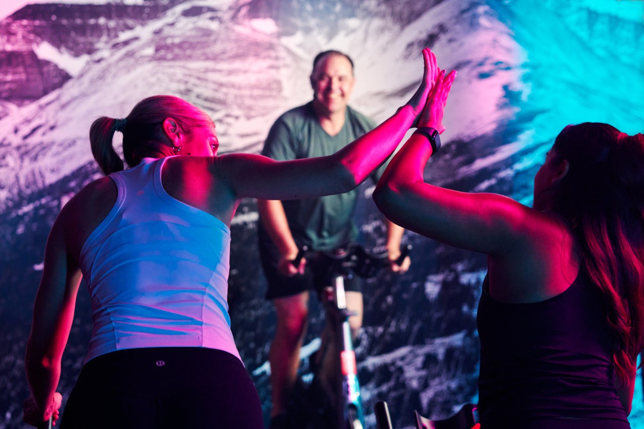 GoodLife Fitness trainer observes a client doing a squat lift.