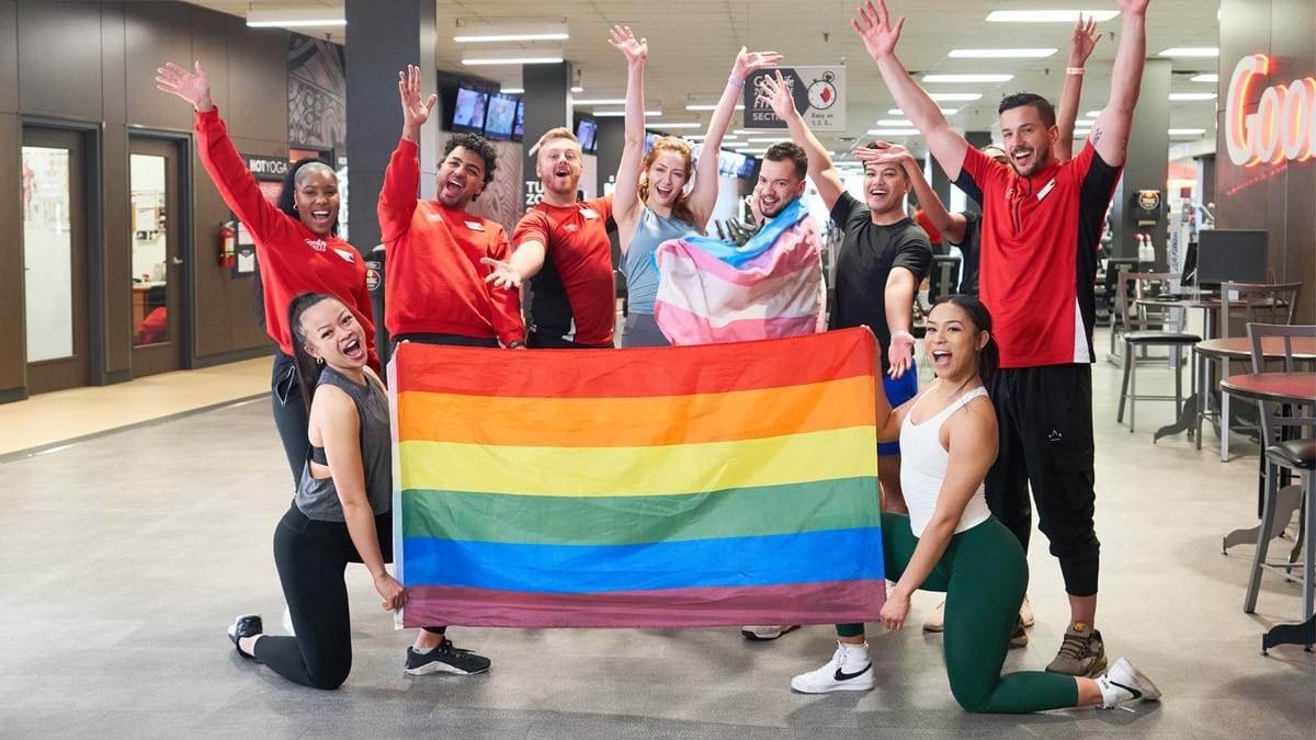 A group of associates holding a pride flag