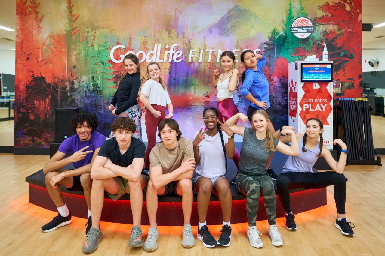 A group of participants of the TeenFitness program posing in a GoodLife Fitness class studio.